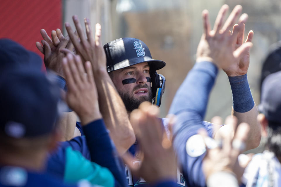 Seattle Mariners' Sam Haggerty is congratulations by teammates after scoring on a single by Carlos Santana during the third inning of a baseball game against the Los Angeles Angels in Anaheim, Calif., Wednesday, Aug. 17, 2022. (AP Photo/Alex Gallardo)