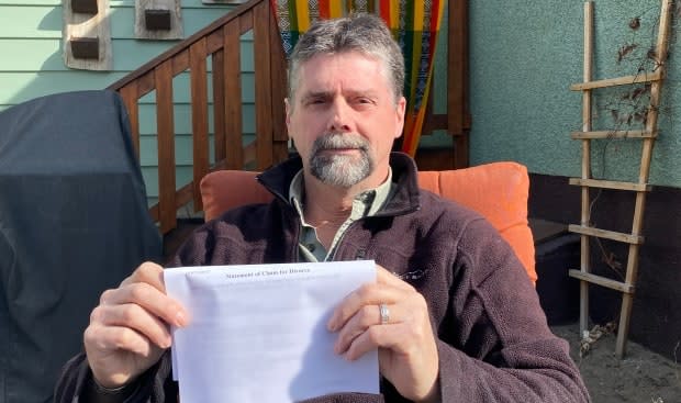 Aaron Penman holds one of the court documents a paralegal claimed had been filed with an Alberta court, only to discover the court had no record of it. (Peter Cameron-Inglis/CBC - image credit)