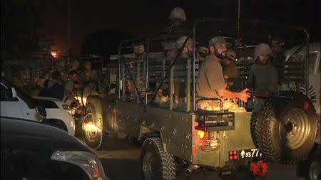 Soldiers sit in a vehicle at Jinnah International Airport in Karachi June 9, 2014 in this still image taken from video. Gunmen attacked one of Pakistan's biggest airports in Karachi on Sunday, killing at least five people, police said. REUTERS/Reuters TV