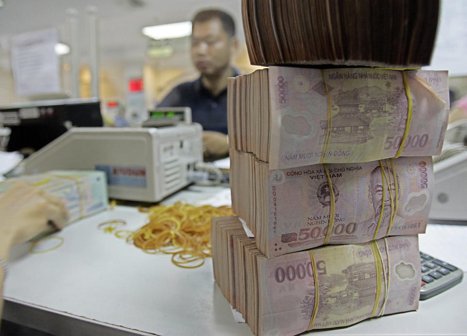 FILE - Vietnamese money dong is seen at the Asia Commercial Bank in Hanoi, Vietnam, in this June 16, 2008, file photo. The U.S. Treasury Department has branded Vietnam and Switzerland as currency manipulators while putting China and nine other countries on a watch list in an annual report designed to halt countries from manipulating their currencies to gain unfair trade advantages. (AP Photo/Chitose Suzuki, File)