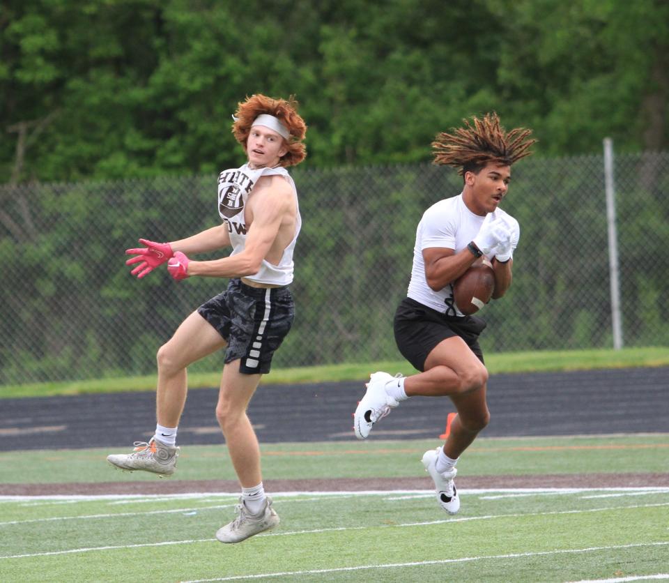 Heath's Jakhi Royster makes an interception while defending Tyler Marks during a Licking County college football scouting combine on Thursday.