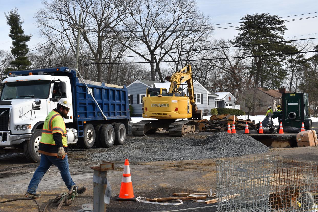 A member of an emergency contractor crew walks through the scene of a sewer main collapse on Leon Avenue in Delran on Tuesday, Jan. 23, 2024.