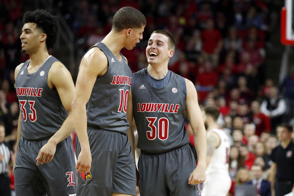 Louisville's Ryan McMahon (30) celebrates one of his 3-point shots with teammate Samuell Williamson (10) during the first half of an NCAA college basketball game against North Carolina State in Raleigh, N.C., Saturday, Feb. 1, 2020. (AP Photo/Karl B DeBlaker)