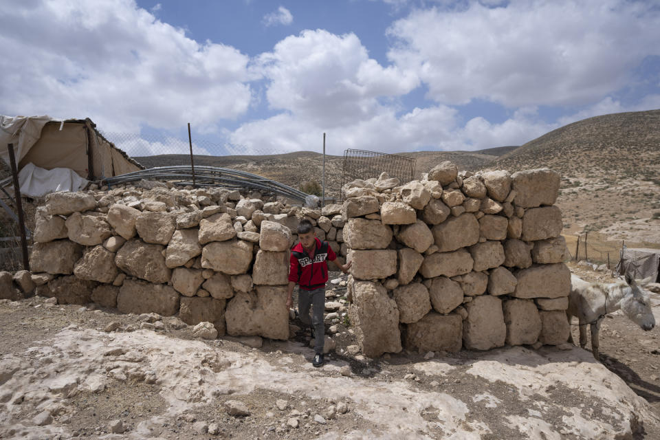 A Palestinian child walks in the West Bank Beduin community of Jinba, Masafer Yatta, Friday, May 6, 2022. Israel's Supreme Court has upheld a long-standing expulsion order against eight Palestinian hamlets in the occupied West Bank, potentially leaving at least 1,000 people homeless. (AP Photo/Nasser Nasser)