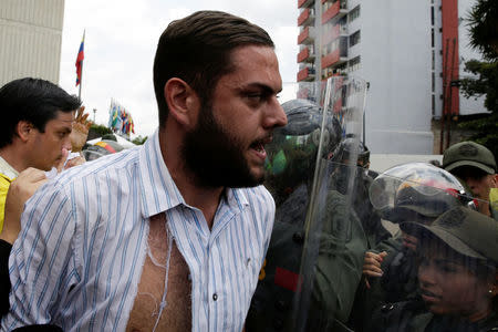 Juan Requesens, deputy of the Venezuelan coalition of opposition parties (MUD), clashes with Venezuela's National Guards during a protest outside the Supreme Court of Justice (TSJ) in Caracas, Venezuela March 30, 2017. REUTERS/Marco Bello