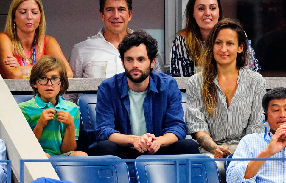 Cassius Riley, Penn Badgley and Domino Kirke watch a tennis match at the 2019 US Open