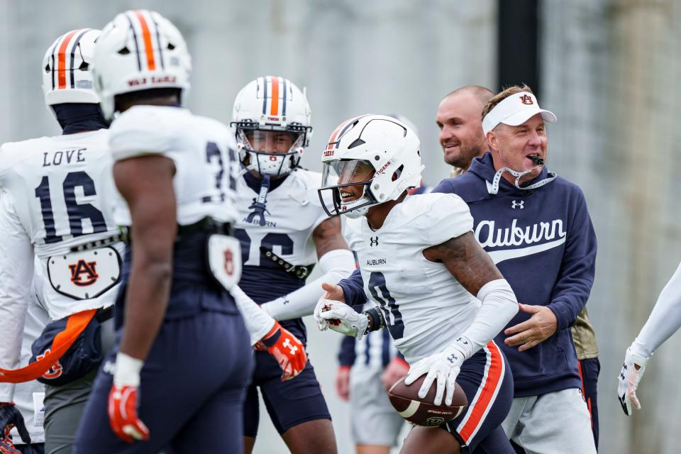 Auburn football coach Hugh Freeze celebrates with defensive back Keionte Scott (0) during a bowl practice at the Woltosz Football Performance Center on Dec. 16, 2023.