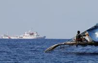 A Philippine fisherman watches a China Coast Guard vessel patrolling the disputed Scarborough Shoal, April 5, 2017. Picture taken April 5, 2017. REUTERS/Erik De Castro