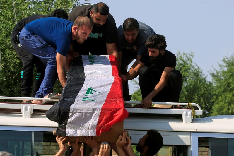 Mourners carry the coffin of a protester, draped in an Iraqi flag, who was killed at protests in Baghdad, during a funeral in the holy city of Najaf