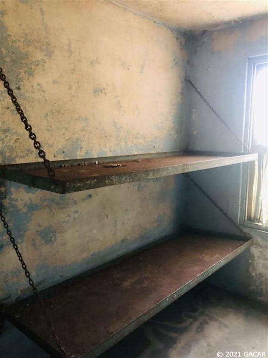 Two rusty beds inside an old abandoned jail