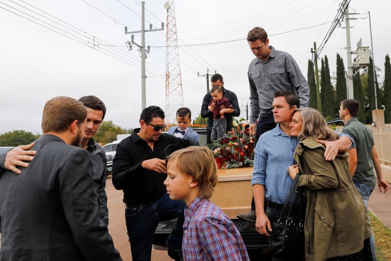 Relatives of Christina Marie Langford Johnson, who was killed by unknown assailants, stand next to her coffin during the funeral service before a burial at the cemetery in LeBaron, Chihuahua