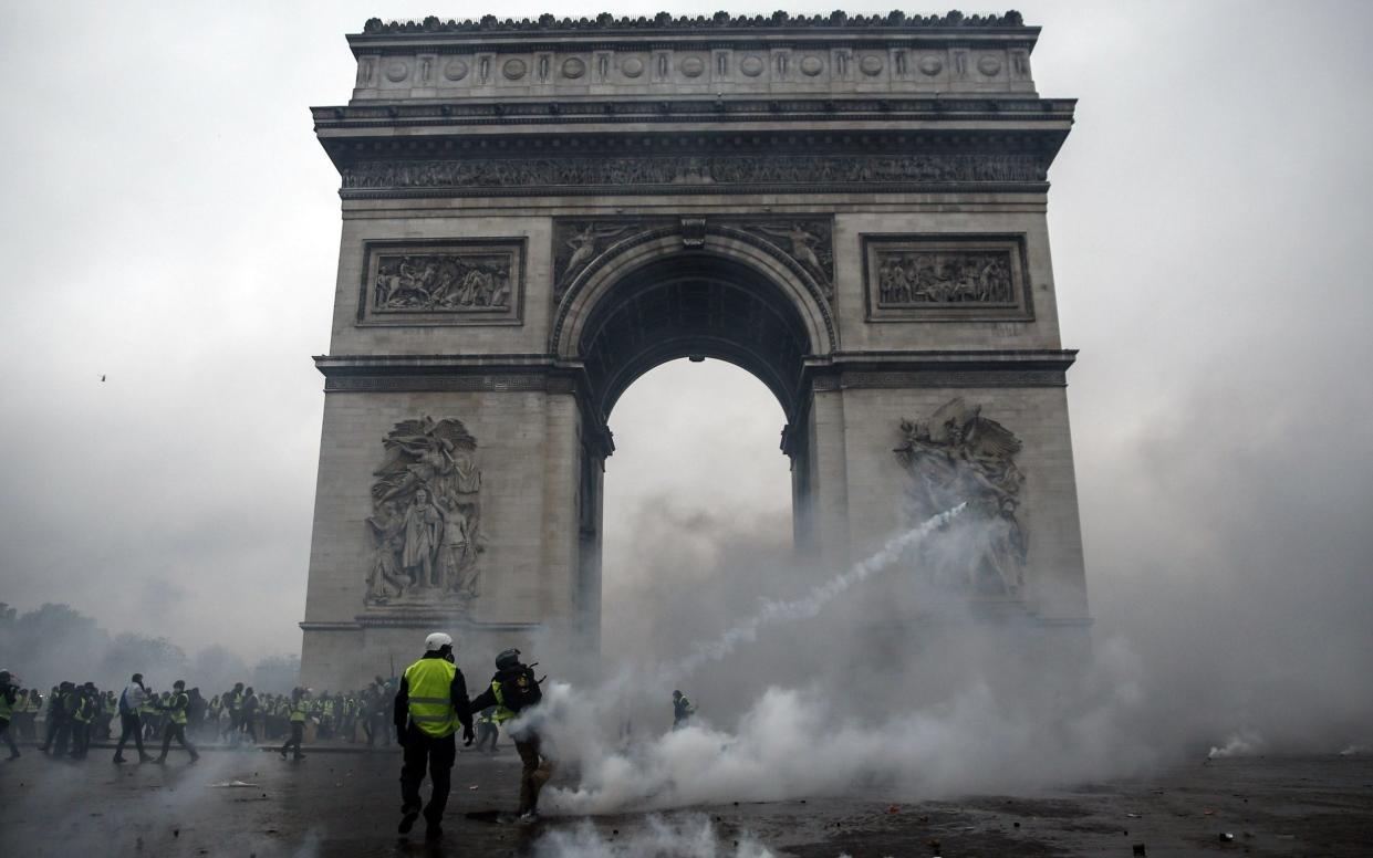 Demonstrators clash with riot police at the Arc de Triomphe  - AFP