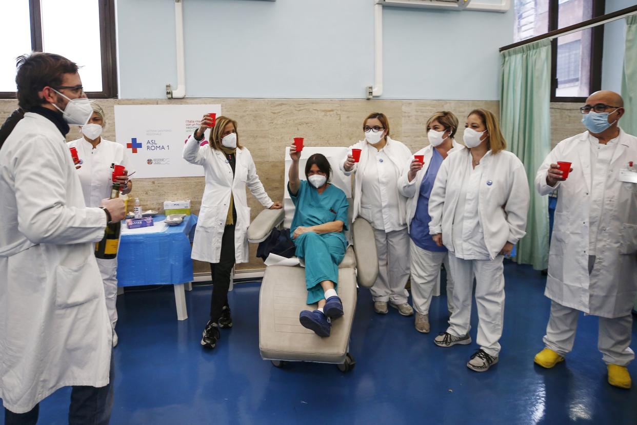 Medical staff makes a toast to the new year at the vaccine center of Santo Spirito Hospital in Rome, Italy on Friday, Jan. 1, 2021. Over 32,000 doses of the COVID-19 vaccine were given to doctors and nurses in Italy to date, as the vaccine campaign goes on.