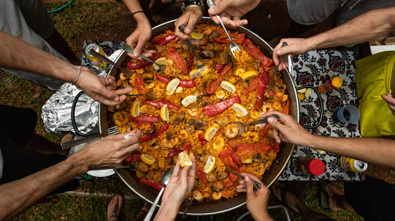 People sharing pan of paella