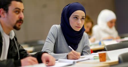 Migrants who worked as teachers in their home countries takes part in a programme to educate them for German schools at the University in Potsdam, Germany, April 14, 2016. REUTERS/Hannibal Hanschke