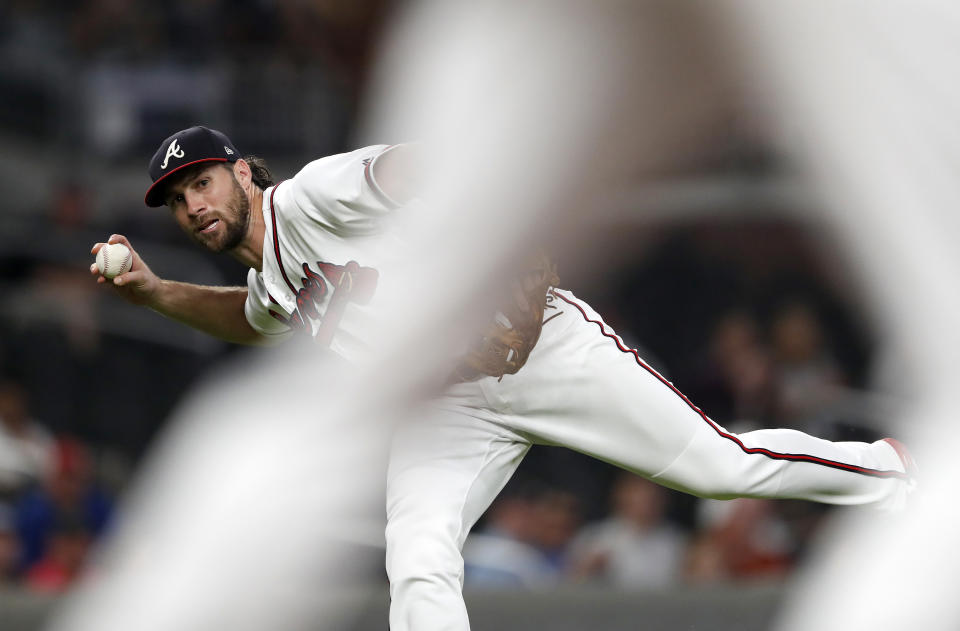 Atlanta Braves third baseman Charlie Culberson (16) is framed by first baseman Freddie Freeman as he throws out Miami Marlins' Austin Dean after bare-handing a ground ball during the fourth inning of a baseball game Wednesday, Aug. 15, 2018, in Atlanta. (AP Photo/John Bazemore)
