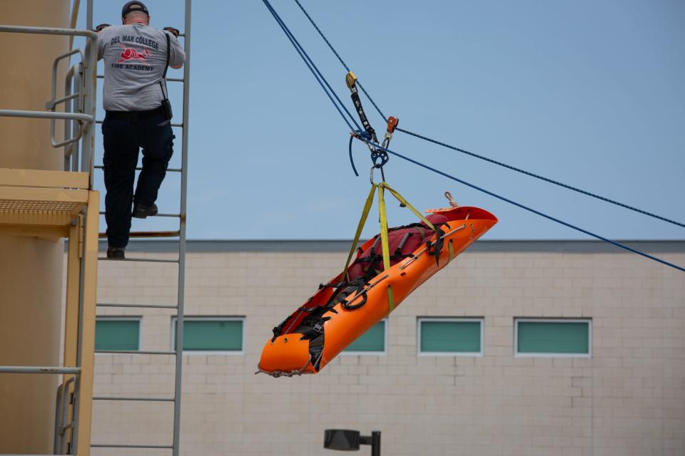 Corpus Christi Firefighter Brad Crabtree climbs down a ladder after securing a rescue stretcher to a rope during a rope rescue demonstration at Del Mar College Windward Campus on Wednesday, May 15, 2024, in Texas.