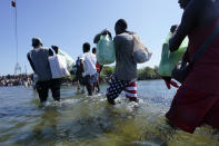 Haitian migrants use a dam to cross to and from the United States from Mexico, Friday, Sept. 17, 2021, in Del Rio, Texas. Thousands of Haitian migrants have assembled under and around a bridge in Del Rio presenting the Biden administration with a fresh and immediate challenge as it tries to manage large numbers of asylum-seekers who have been reaching U.S. soil. (AP Photo/Eric Gay)