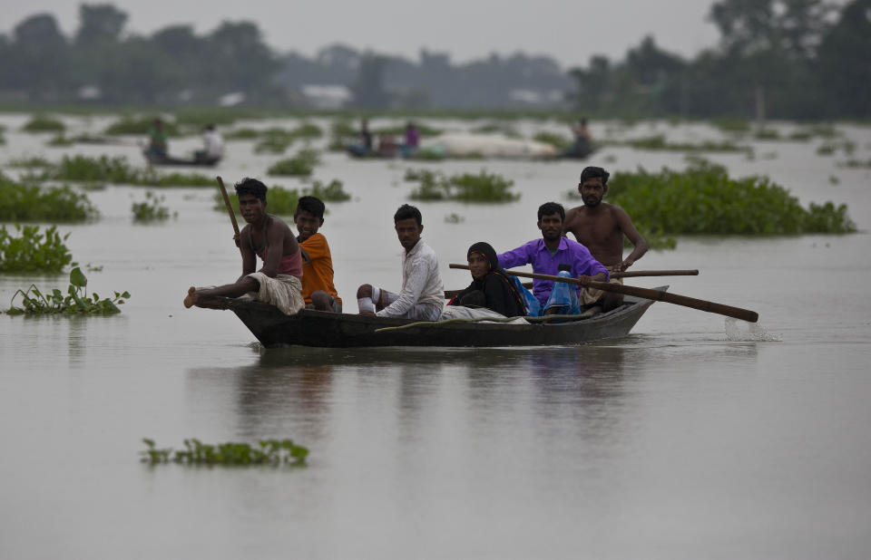 Indian flood affected villagers travel on boats in Burha Burhi village, east of Gauhati, Assam, India, Monday, July 15, 2019. After causing flooding and landslides in Nepal, three rivers are overflowing in northeastern India and submerging parts of the region, affecting the lives of more than 2 million, officials said Monday. (AP Photo/Anupam Nath)