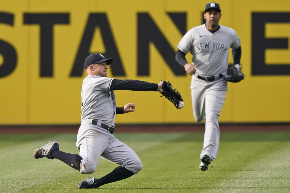 New York Yankees' Brett Gardner, left, tries to catch a ball hit by Cleveland Indians' Cesar Hernandez in the first inning of a baseball game, Thursday, April 22, 2021, in Cleveland. Gardner could not hold onto the ball for the out and Hernandez was safe with a single. (AP Photo/Tony Dejak)