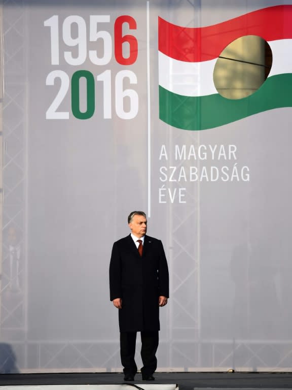 Hungarian Prime Minister Viktor Orban stands under the symbol of 1956 revolution in front of the parliament building in Budapest on October 23, 2016