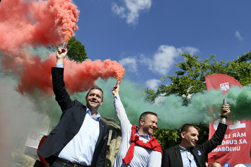 From left to right: President and top candidate of the Hungarian Socialist Party Bertalan Toth, Istvan Ujhelyi, representative of the European Parliament, member and candidate of the oppositional Hungarian Socialist Party (MSZP) and Benedek Javor, representative of the European Parliament and candidate of the oppositional Parbeszed (Dialogue) party L-R) hold a smoke flare during the final EP campaign event of the parties at the Clark Adam square in Budapest, Hungary, Saturday, May 25, 2019. The European Parliament election is held by member countries of the European Union (EU) from 23 to 26 May 2019. (Szilard Koszticsak/MTI via AP)