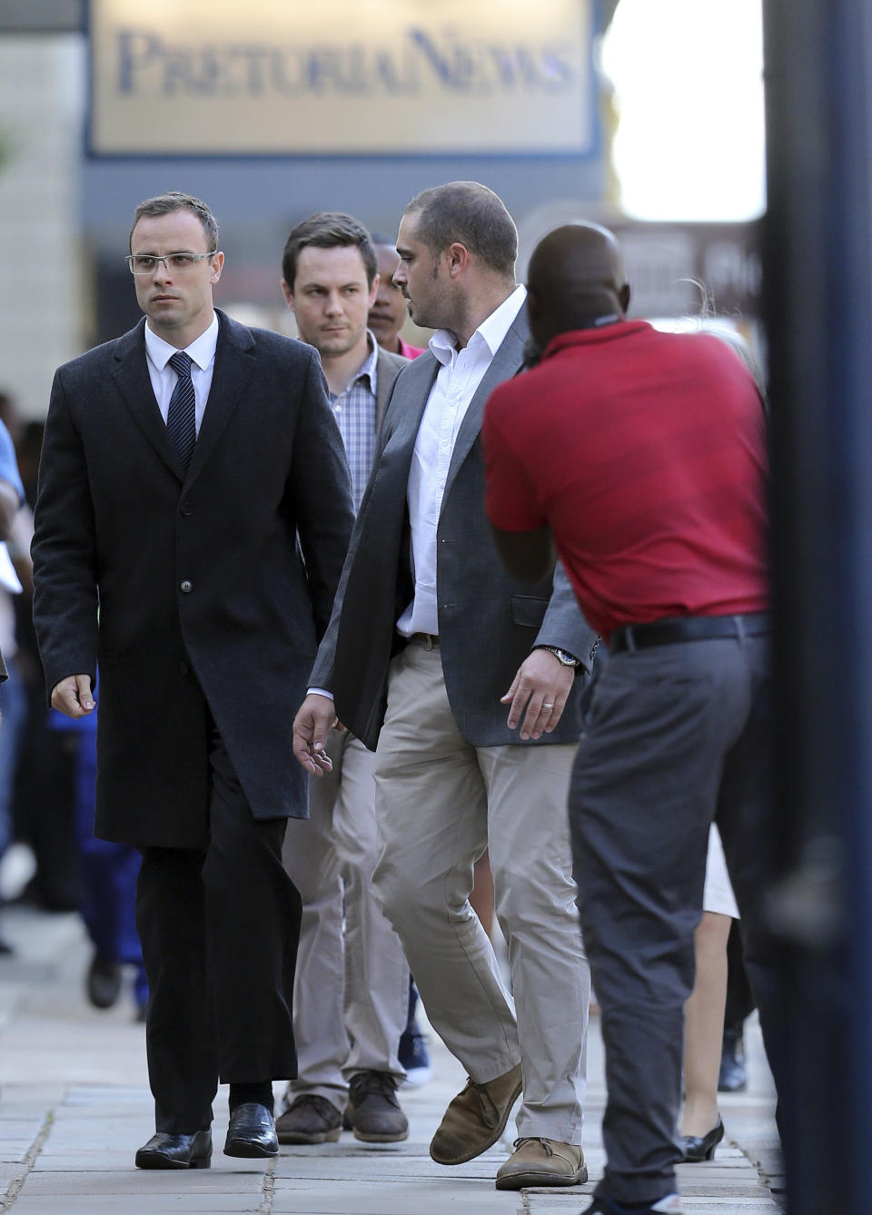 Oscar Pistorius, left, accompanied by his relatives, walks towards the high court in Pretoria, South Africa, Tuesday, April 8, 2014. Pistorius, who is charged with murder for the shooting death of his girlfriend, Reeva Steenkamp, on Valentines Day in 2013, was testifying for a second day at his murder trial Tuesday, answering questions from his defense lawyer. (AP Photo/Themba Hadebe)