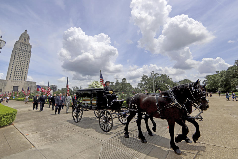 A horse-drawn carriage carries former Louisiana Gov. Edwin Edwards away from the Louisiana State Capitol in Baton Rouge, La., Sunday, July 18, 2021. A processional featuring a law enforcement motorcade and the Southern University Marching Band was held though the streets of downtown Baton Rouge, ending at the Old State Capital building where a private funeral service was held. The colorful and controversial four-term governor died of a respiratory illness on Monday, July 12th at the age of 93. (AP Photo/Michael DeMocker)