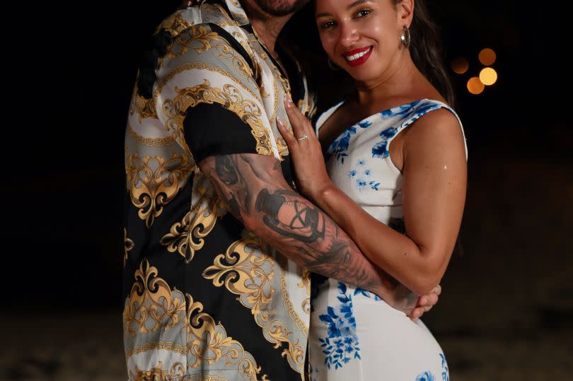 Couple looking loving into the camera after their proposal