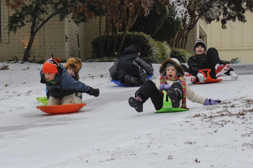 Neighborhood children gather for some sledding on the ice left by the winter storm in Fairview, Texas, on Friday, Dec. 6, 2013.