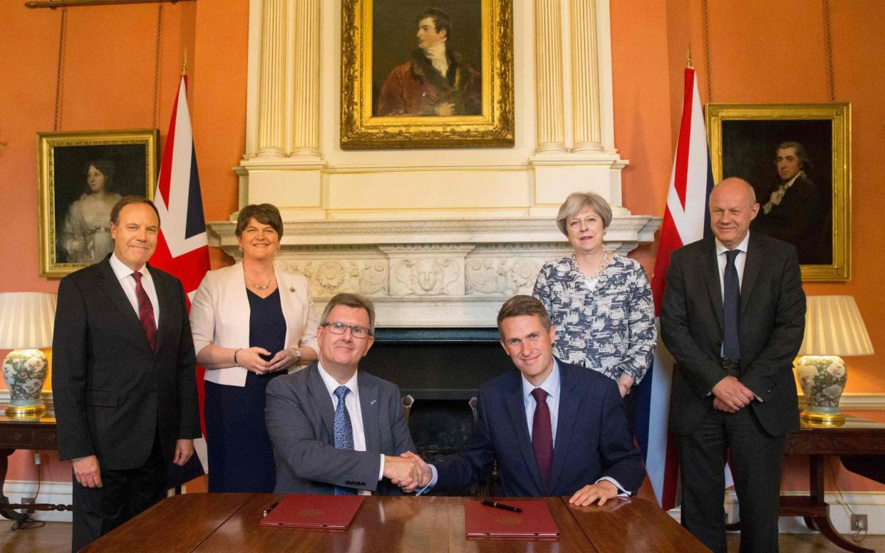 Theresa May (2R) stands with Britain's First Secretary of State Damian Green (R), Democratic Unionist Party (DUP) leader Arlene Foster (2L), DUP Deputy Leader Nigel Dodds (L), as DUP MP Jeffrey Donaldson (3L) shakes hands with Britain's Parliamentary Secretary to the Treasury, and Chief Whip, Gavin Williamson, inside 10 Downing Street - AFP