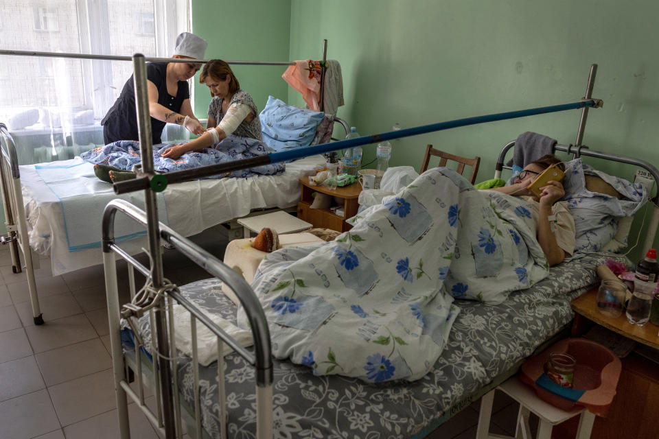 KRYVYI RIH, UKRAINE - MAY 05: A nurse checks the wounds of Ponomareva Natalia Sergiivna, 41, three days after her family's home was shelled by Russian forces in their frontline village of Vysokopilla in the Kherson region of southern Ukraine on May 05, 2022 in Kryvyi Rih, Ukraine. She said the family escaped while still under fire to a Ukrainian army checkpoint and was then transported to a regional trauma hospital. Her daughter, 5, was seriously injured and just released from the intensive care unit of another hospital. The central Ukrainian city and district of Kryvyi Rih, known as an industrial center and the hometown of President Volodymyr Zelensky, lies less than 70km north of Russian-occupied areas in nearby Kherson Oblast, where invading Russian forces have sought to create a land bridge between the Crimean peninsula and  the eastern Donbas region. (Photo by John Moore/Getty Images)