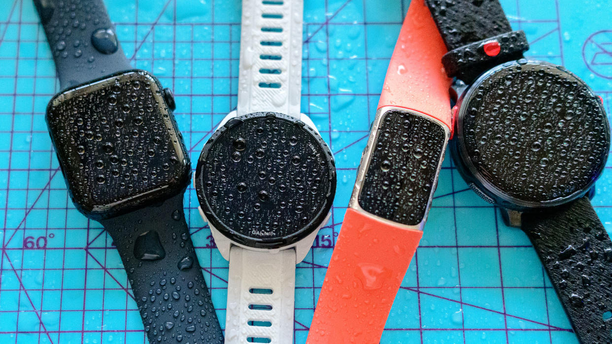  Four smartwatches covered in beads of water. 