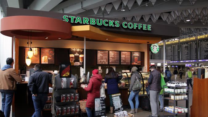 Frankfurt, Germany - April 27, 2016: Passengers waiting for their flight queing up on a Starbucks coffee and snack bar for a little drink or a piece of cake at Frankfurt Airport.