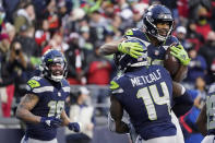 Seattle Seahawks wide receiver Tyler Lockett, upper right, is lifted by wide receiver DK Metcalf (14) after scoring a touchdown against the San Francisco 49ers during the second half of an NFL football game at Lumen Field, Sunday, Dec. 5, 2021, in Seattle. (AP Photo/Elaine Thompson)