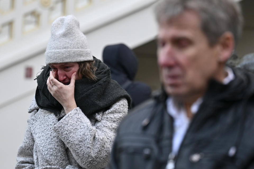 Mourners stand outside the headquarters of Charles University after mass shooting in Prague, Czech Republic, Friday, Dec. 22, 2023. A lone gunman opened fire at a university on Thursday, killing more than a dozen people and injuring scores of people. (AP Photo/Denes Erdos)