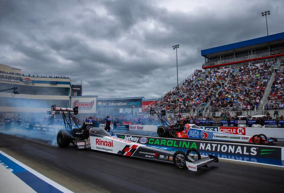 Sep 23, 2023; Concord, NC, USA; NHRA top fuel driver Leah Pruett (near) does a burnout alongside Antron Brown during qualifying for the Carolina Nationals at zMax Dragway.