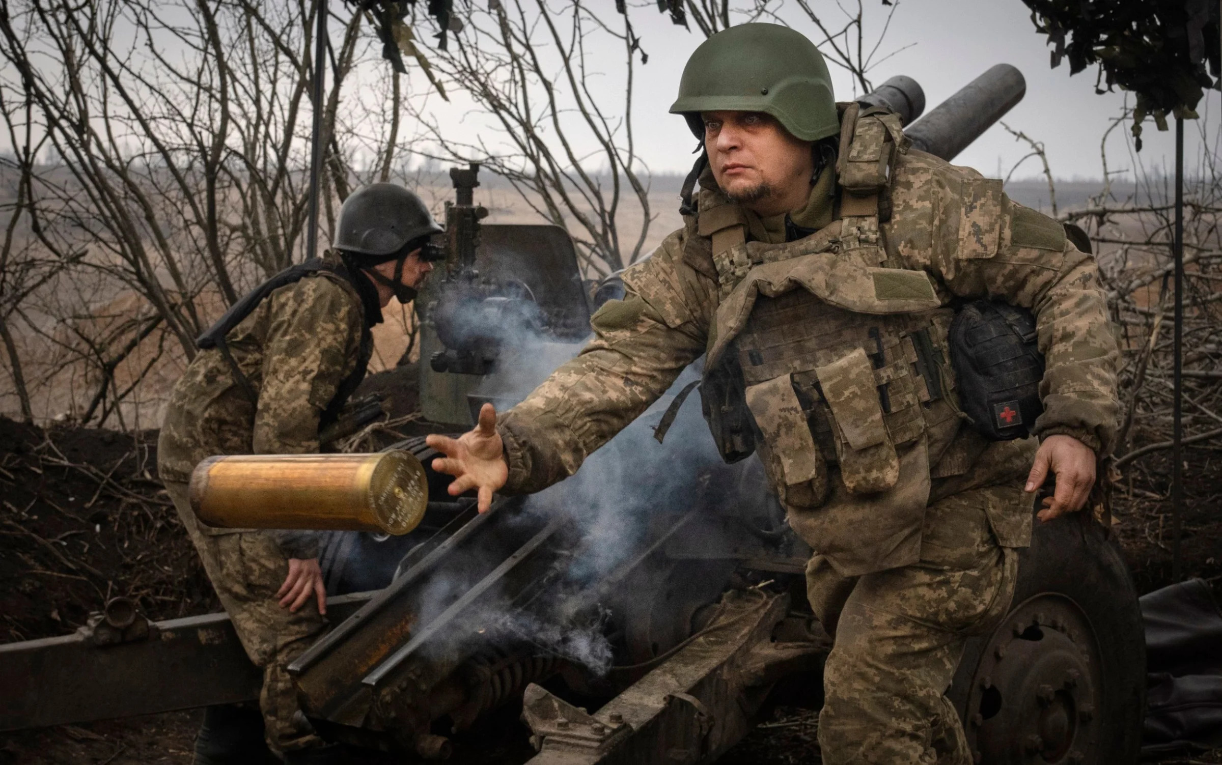 Ukrainian soldiers fire a M101 howitzer towards Russian positions at the frontline