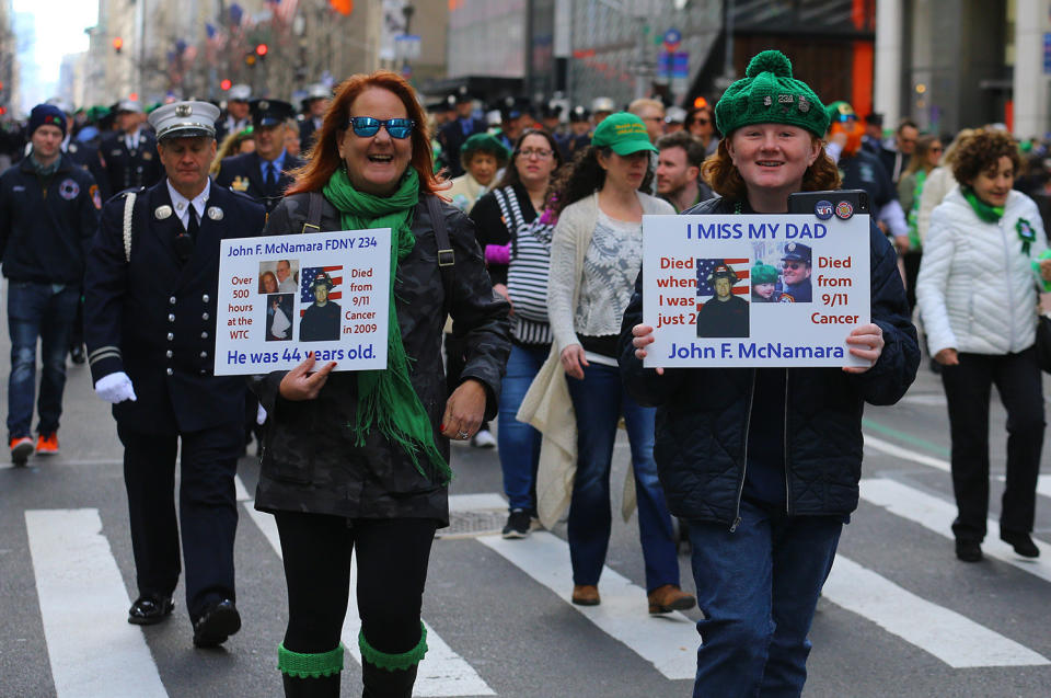 Family members of fallen firefighters hold up signs of loved ones march  in the 2019 NYC St. Patrickâs Day Parade, March 16, 2019. (Photo: Gordon Donovan/Yahoo News)