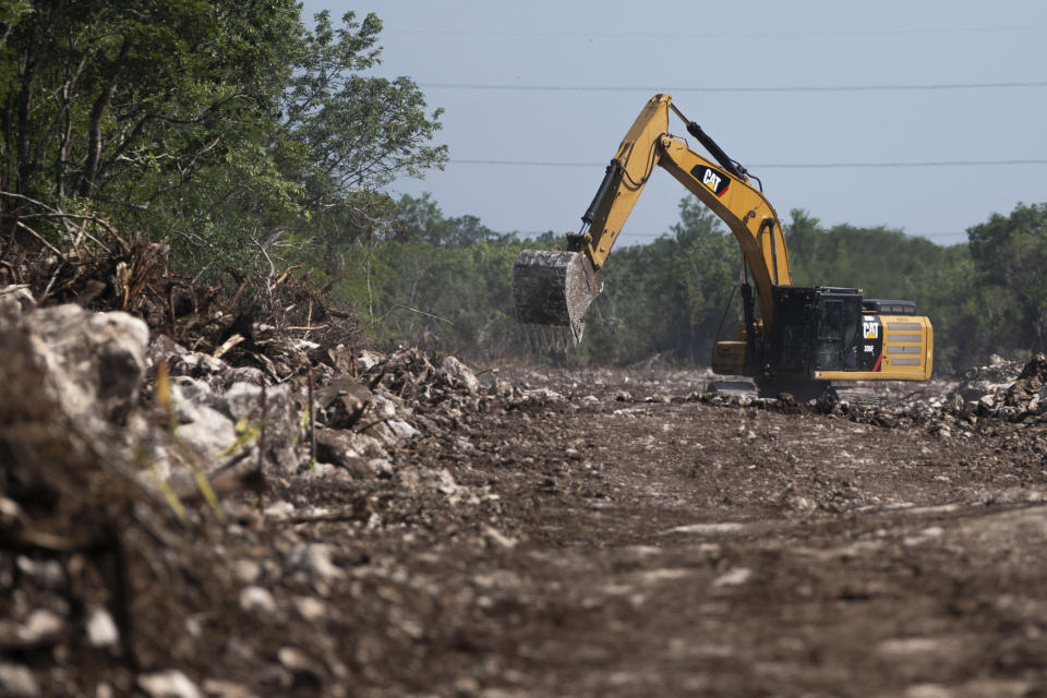 Una excavadora despeja una parte de la selva por donde deberá pasar el Tren Maya en Puerto Morelos (México) el 2 de agosto del 2022. (AP Photo/Eduardo Verdugo)