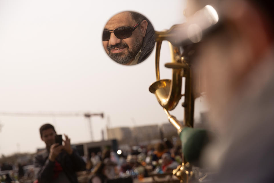 Egyptian collector Mohamed Wahdan is reflected on the mirror of a 1924 Ford T at a public show in Cairo, Egypt, Saturday, March 19, 2022. The car once belonged to Egypt's King Farouk's and is a part of over 250 vintage, antique and classic cars Wahdan collected over the past 20 years. (AP Photo/Amr Nabil)