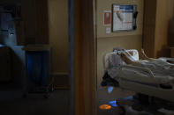 A body of a COVID-19 patient lies in a bed at Providence Holy Cross Medical Center in the Mission Hills section of Los Angeles on Saturday, Jan. 9, 2021. The patient died shortly after receiving the sacrament of anointing of the sick administered over the phone by a priest. (AP Photo/Jae C. Hong)