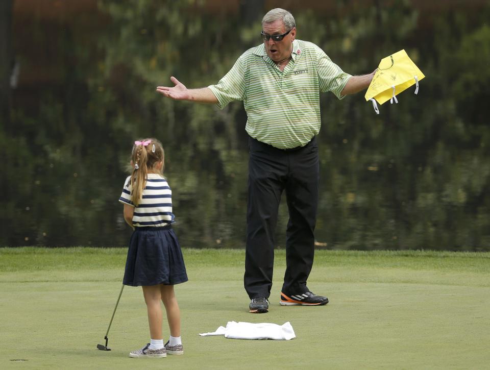 Fuzzy Zoeller of the U.S. reacts as a young girl he pulled from the crowd tries a putt during the par 3 event held ahead of the 2015 Masters at Augusta National Golf Course in Augusta, Georgia April 8, 2015. REUTERS/Brian Snyder