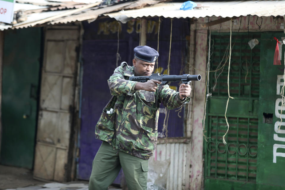 A policeman fires tear gas in the Kibera slums as police clash with demonstrators during a protest by supporters of Kenya's opposition leader Raila Odinga over the high cost of living and alleged stolen presidential vote, in Nairobi, Monday, March 20, 2023. (AP Photo/Brian Inganga)