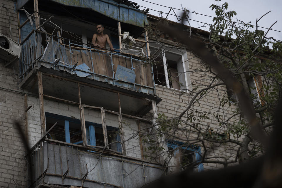 A man stands at the balcony of an apartment in a residential building that was damaged after a Russian attack in Kramatorsk, Ukraine, Wednesday, Aug. 31, 2022. (AP Photo/Leo Correa)
