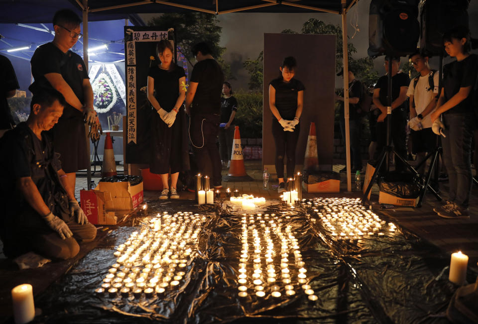 People pay during the one minute silent at a vigil to mourn the recent suicide of a woman due to the government's policy on the extradition bill in Hong Kong Saturday, July 6, 2019. A vigil is being held in Hong Kong for a woman who fell to her death this week, one of three apparent suicides linked to ongoing protests over fears that freedoms are being eroded in this semi-autonomous Chinese territory. (AP Photo/Vincent Yu)