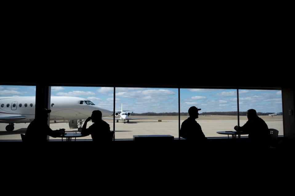 Four men sit inside the lounge at Duncan Aviation in Battle Creek on Monday, March 28, 2022.