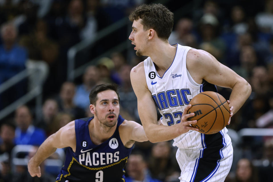 Orlando Magic forward Franz Wagner (22) is defended by Indiana Pacers guard T.J. McConnell (9) during the first half of an NBA basketball game Wednesday, Jan. 25, 2023, in Orlando, Fla. (AP Photo/Kevin Kolczynski)