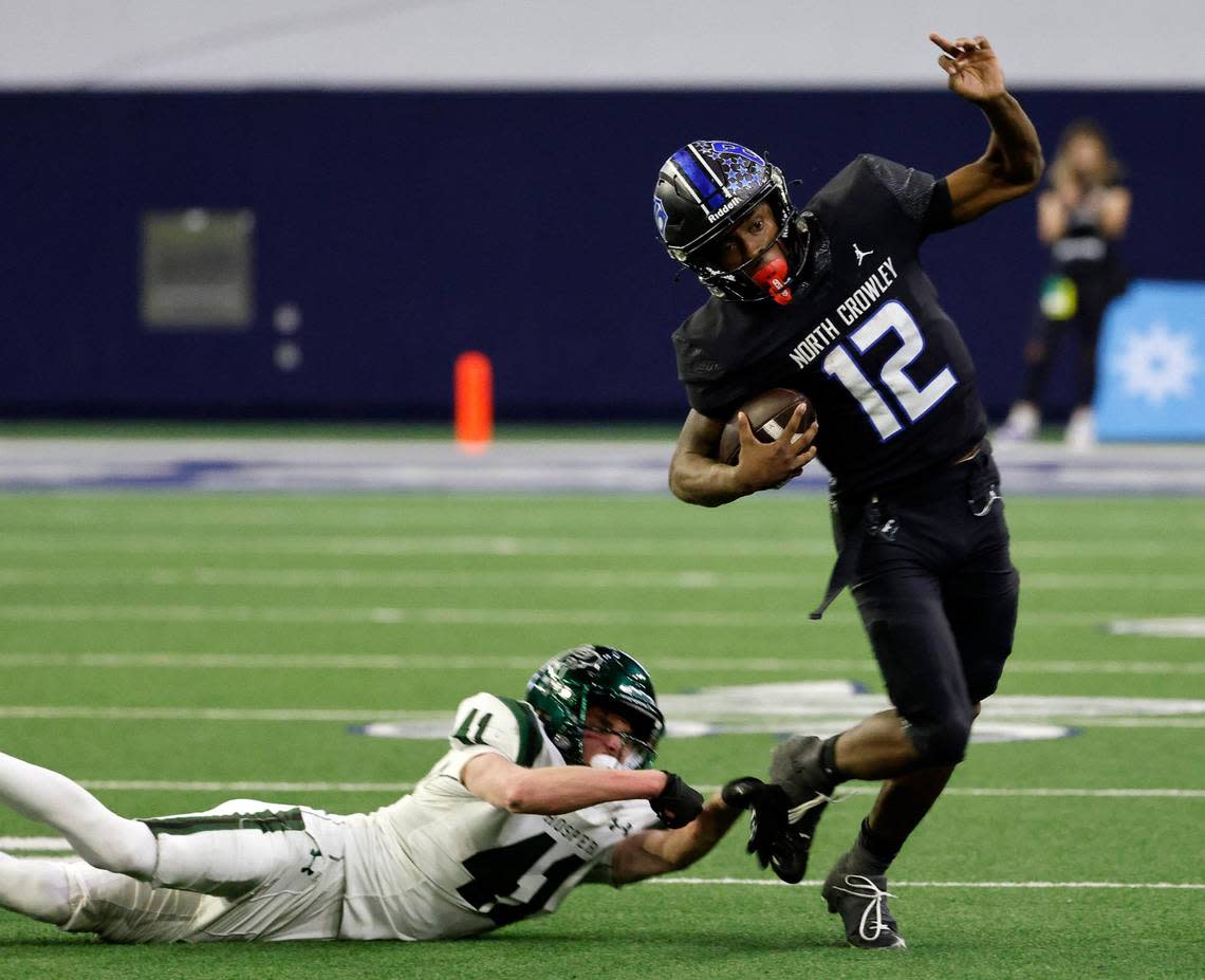 North Crowley quarterback Chris Jimerson (12) sidesteps Prosper defensive back Logan Thompson (41) for yards in the second half of a UIL Class 6A Division 1 football regional-round playoff game at The Ford Center in Frisco, Texas, Saturday, Oct. 25, 2023.