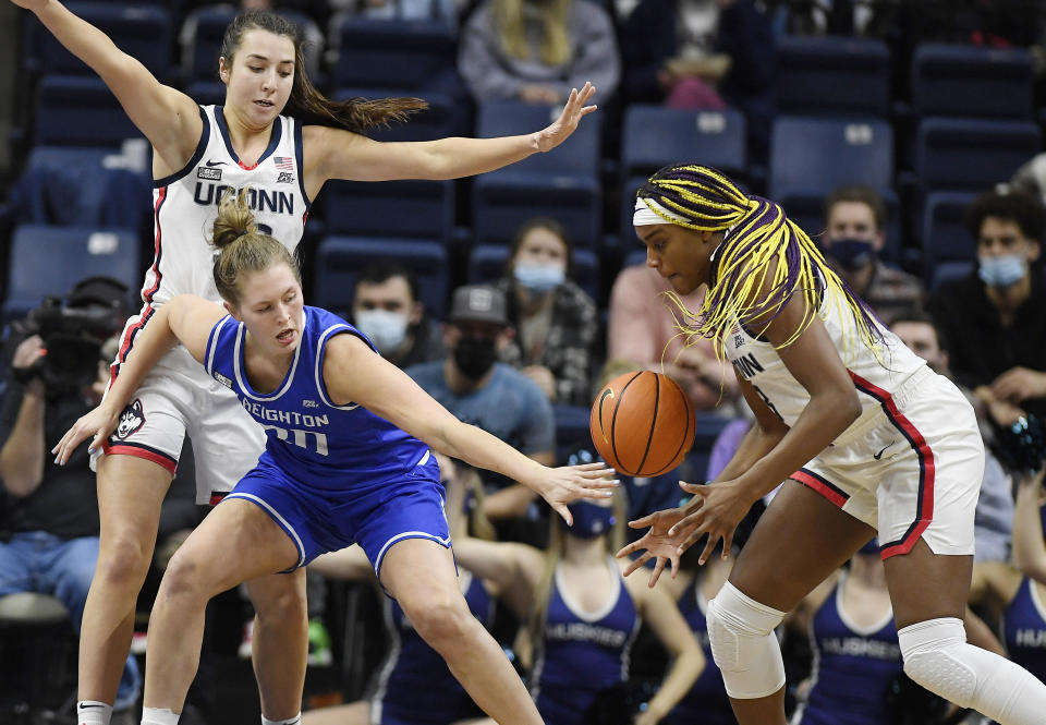 Connecticut's Aaliyah Edwards, right, knocks the ball from Creighton's Morgan Maly as Connecticut's Caroline Ducharme, left, defends in the second half of an NCAA college basketball game, Sunday, Jan. 9, 2022, in Storrs, Conn. (AP Photo/Jessica Hill)